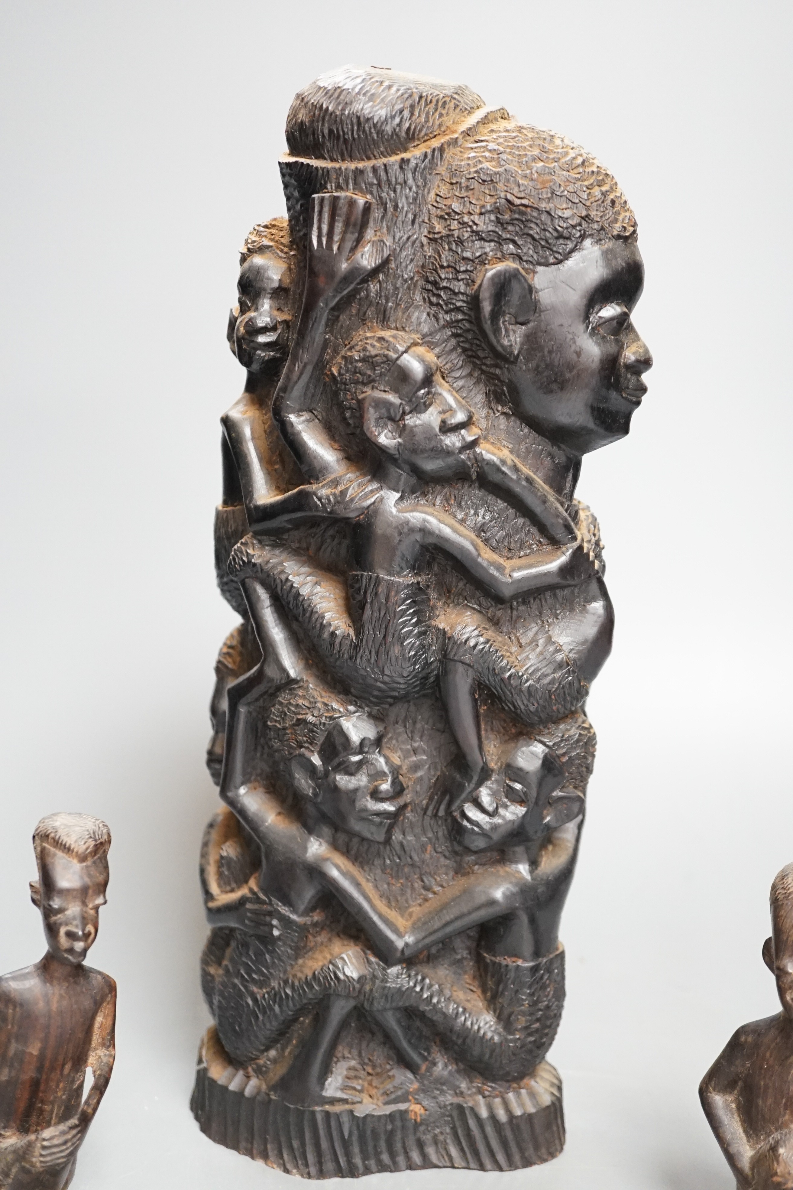 Four tribal hardwood carvings, two bows and two bronze spears longest 85cm